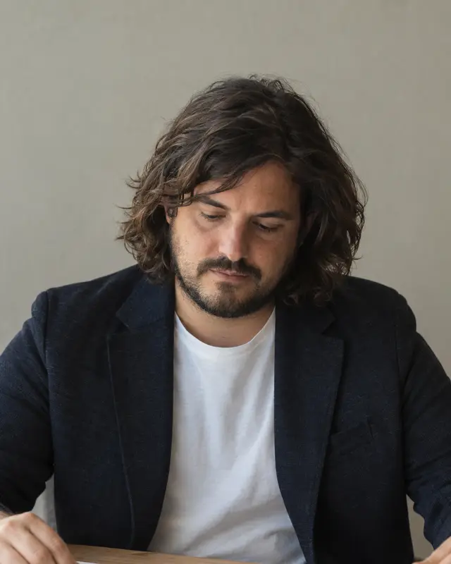 Andrés Ferrer revisando un plano de planta sobre una mesa